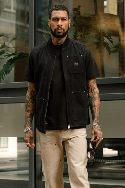 Men's khaki worker pants, black T-shirt and black biker vest outfit