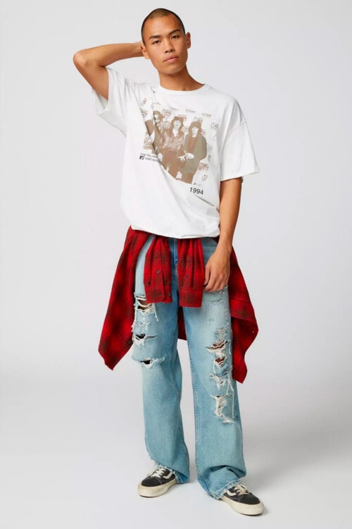 Men's ripped jeans, white printed band T-shirt, black canvas skate shoes and red flannel check shirt outfit