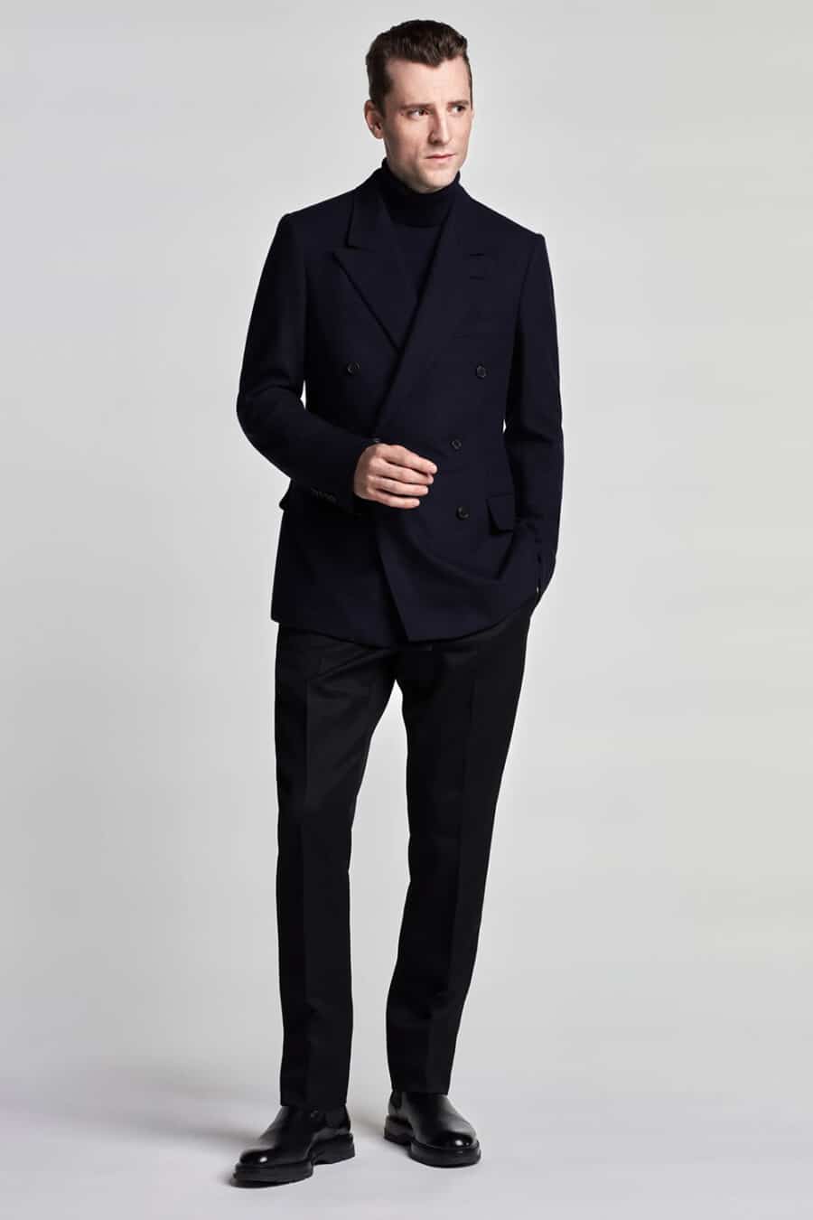 Men's navy double-breasted suit, navy turtleneck and black leather Chelsea boots outfit