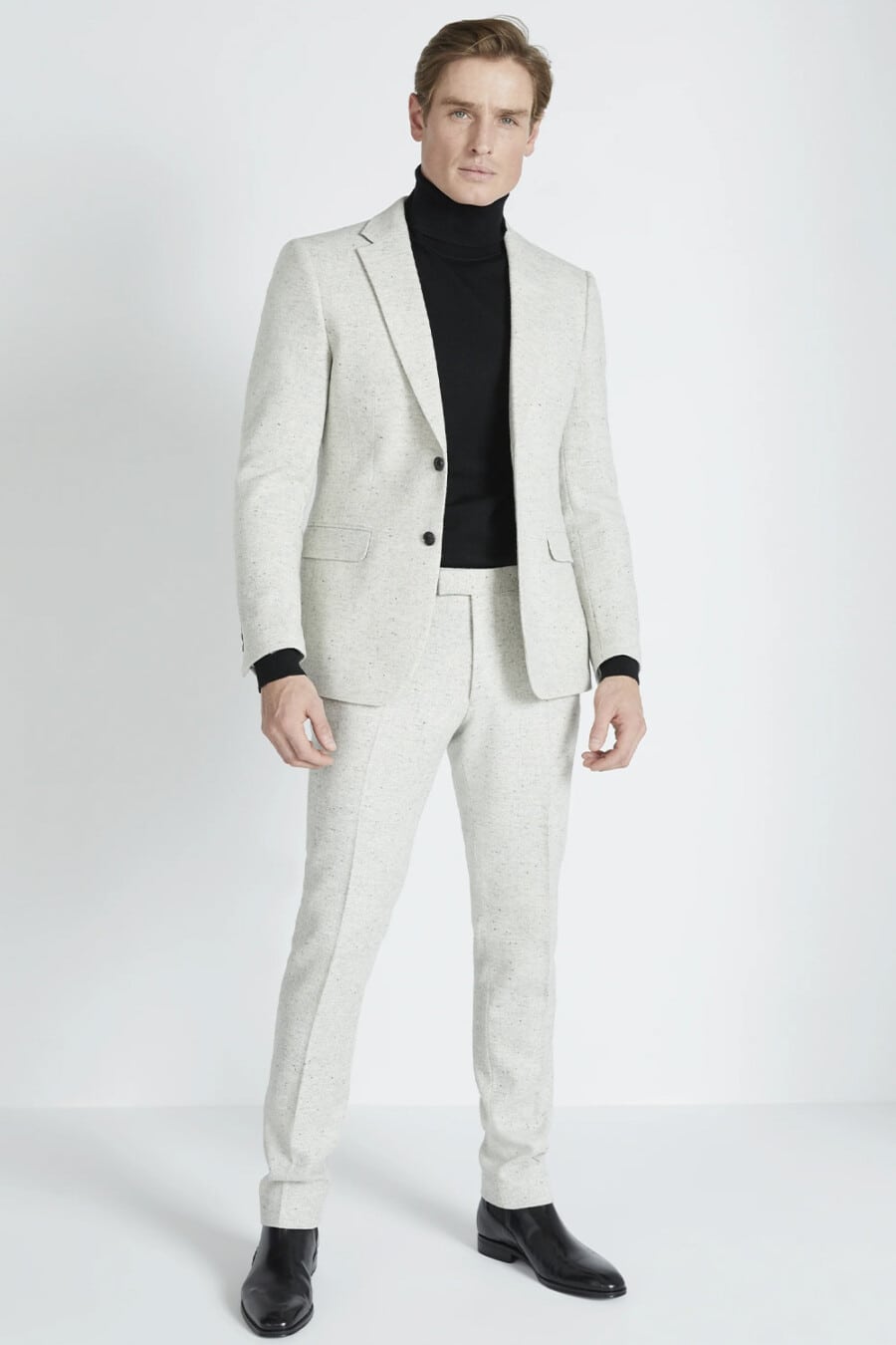 Men's light stone flecked suit, black turtleneck and black leather Chelsea boots outfit