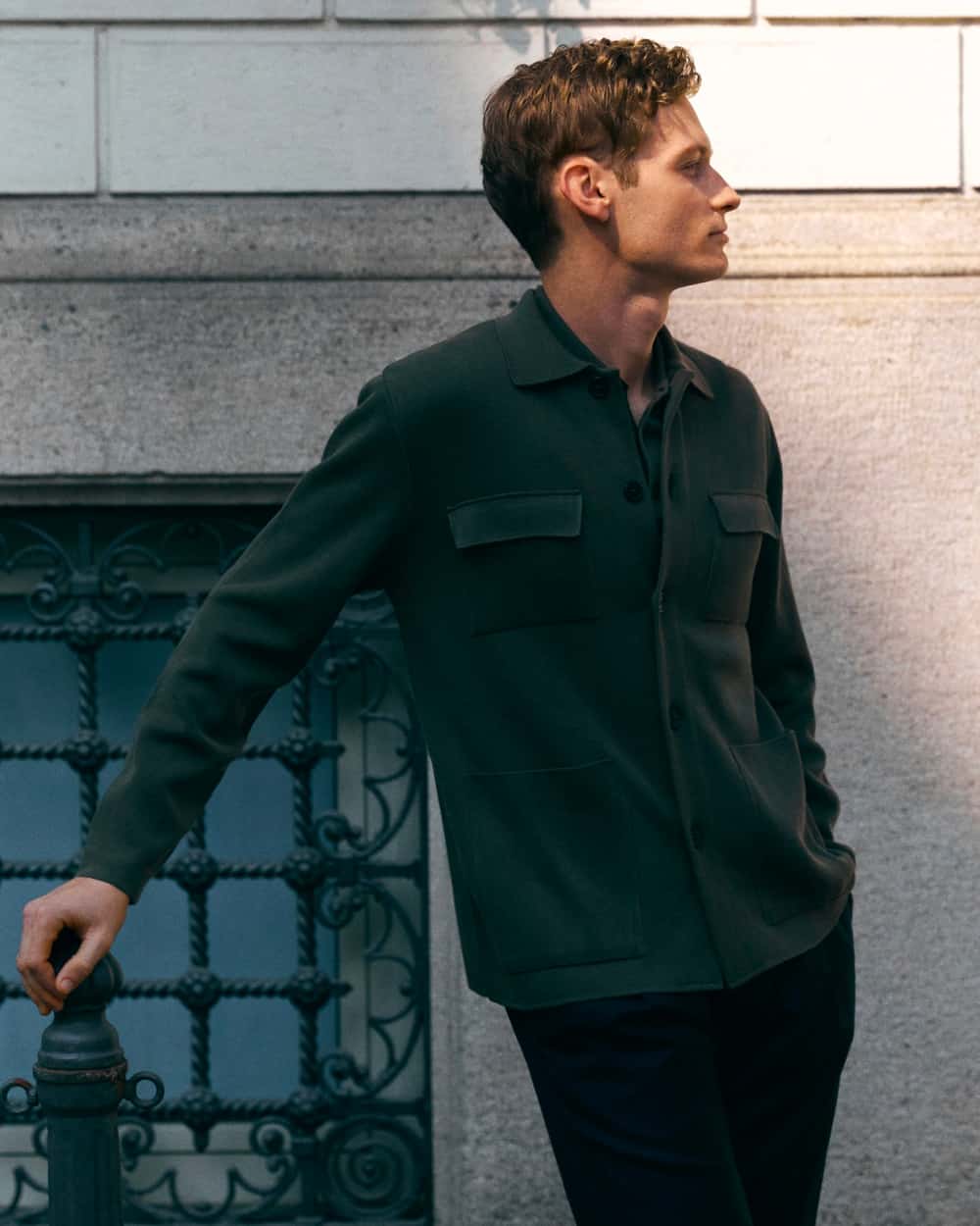 Man wearing a dark green knitted shacket with black pants by Artknit Studios