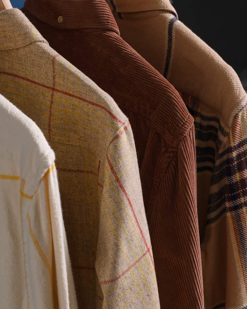 Close up of a selection of Portuguese Flannel shackets in check patterns and corduroy