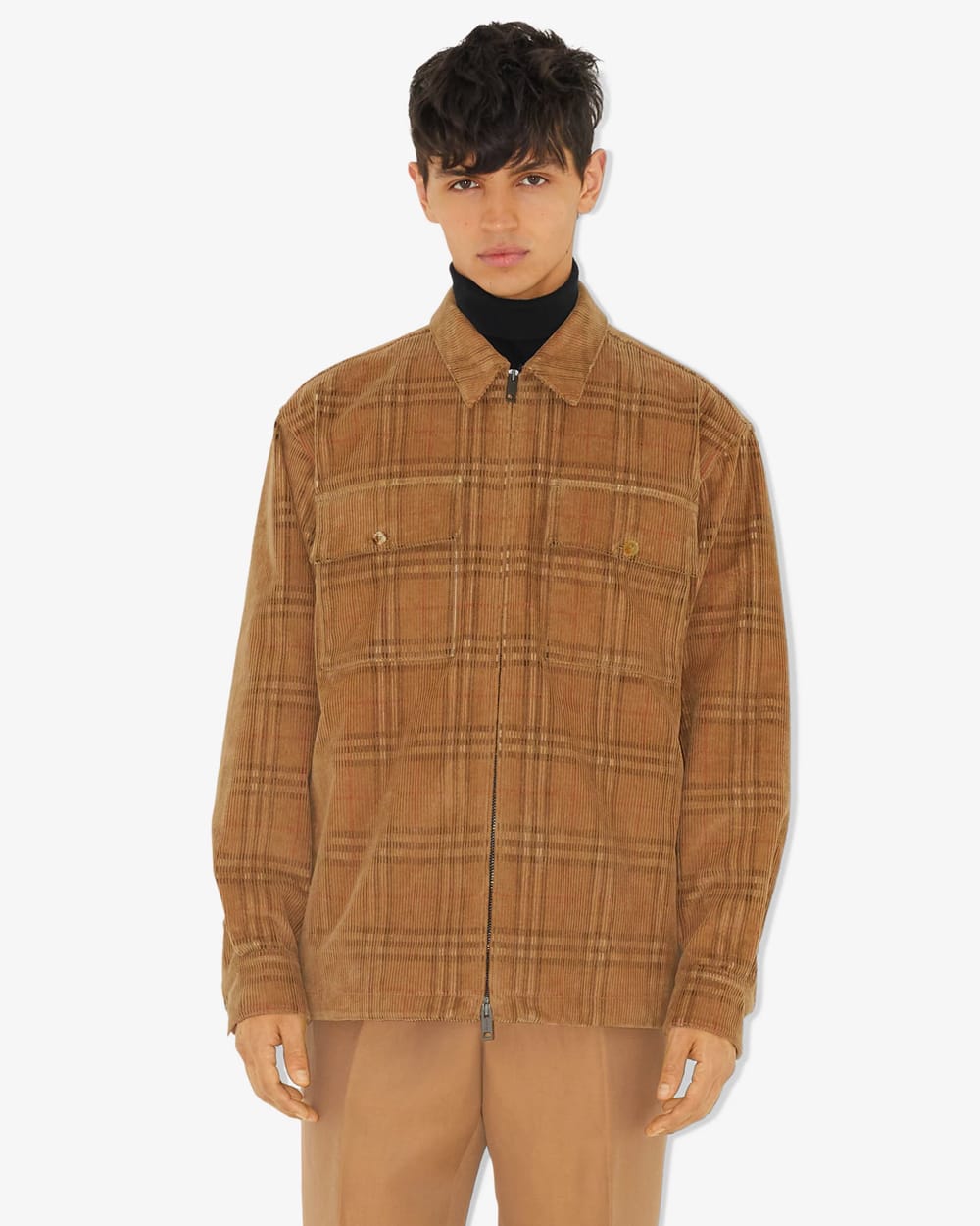 Man wearing a Burberry corduroy check shacket over a black turtleneck with brown pants