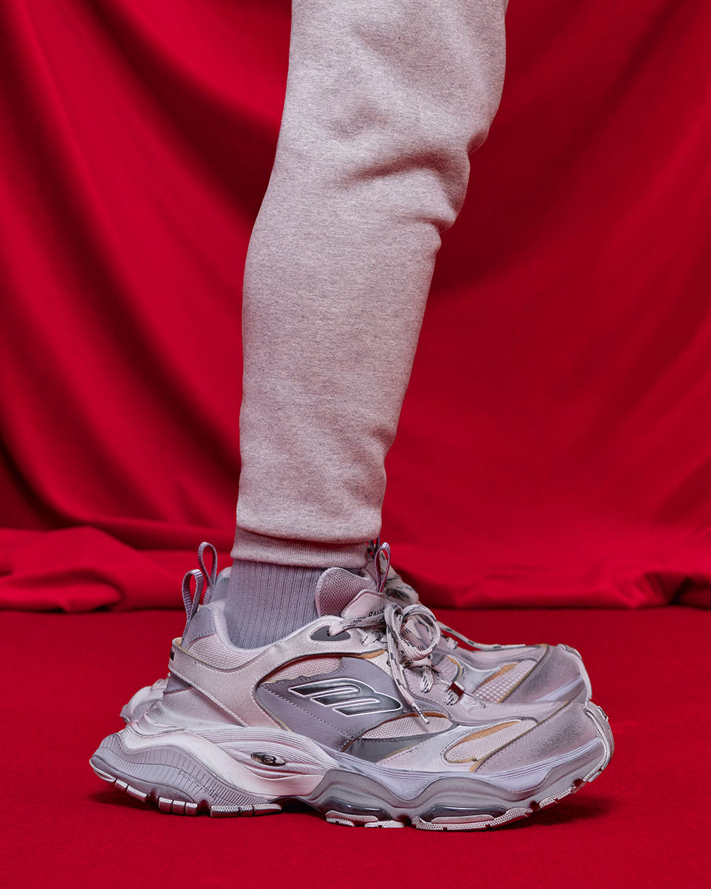 Chunky Balenciaga grey sneakers worn on feet with grey sweatpants and socks