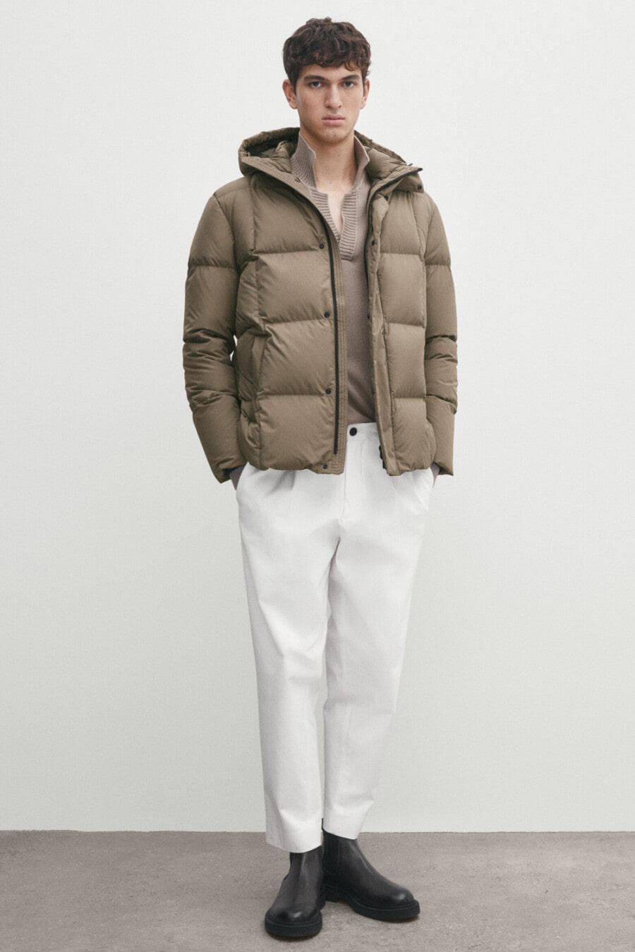 Men's white cropped pants, brown open collar knitted polo shirt, brown puffer jacket and black leather Chelsea boots outfit