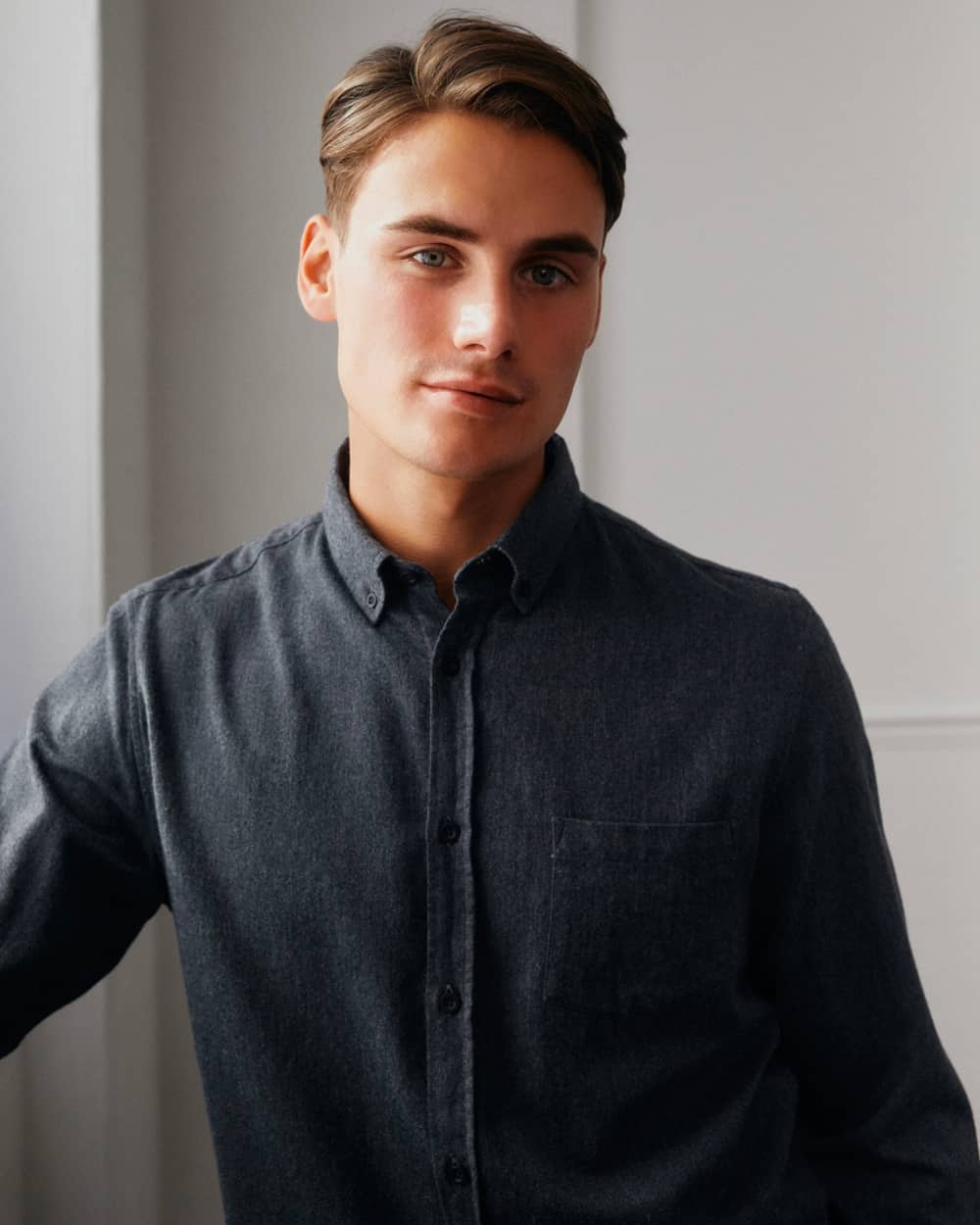 Close up of a man wearing a charcoal Sunspel flannel shirt