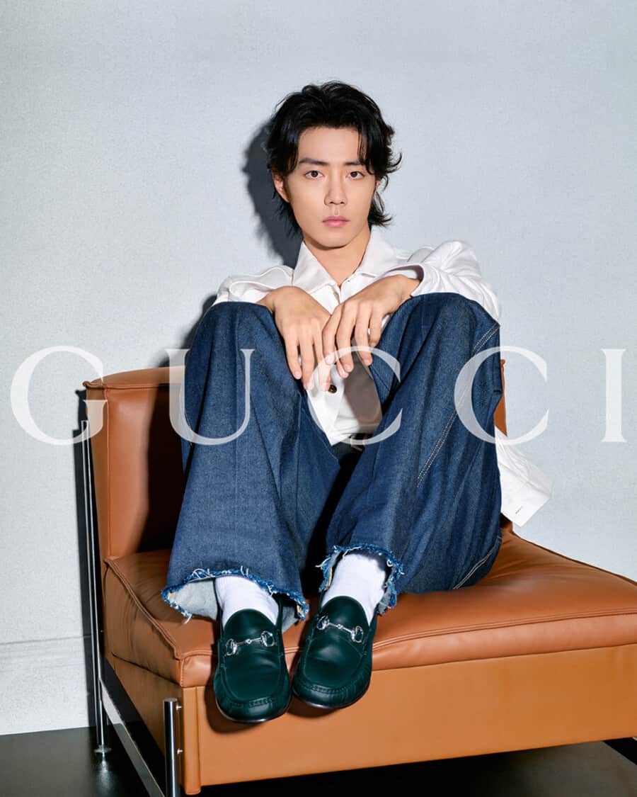 Gucci ad with man wearing black horsebit loafers, dark jeans and white shirt