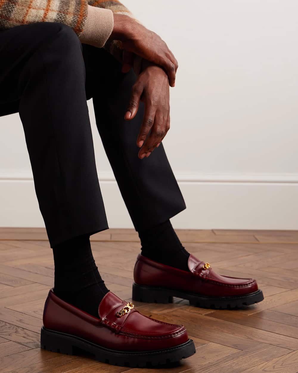 Man wearing burgundy Celine Homme chunky leather bit loafers with black socks and black pants