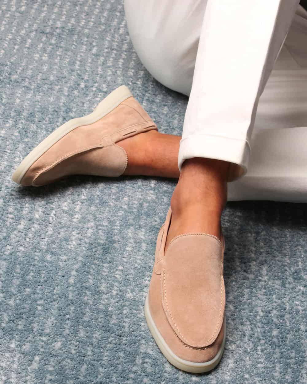Man wearing beige suede slip-on loafers with white tailored pants and no socks