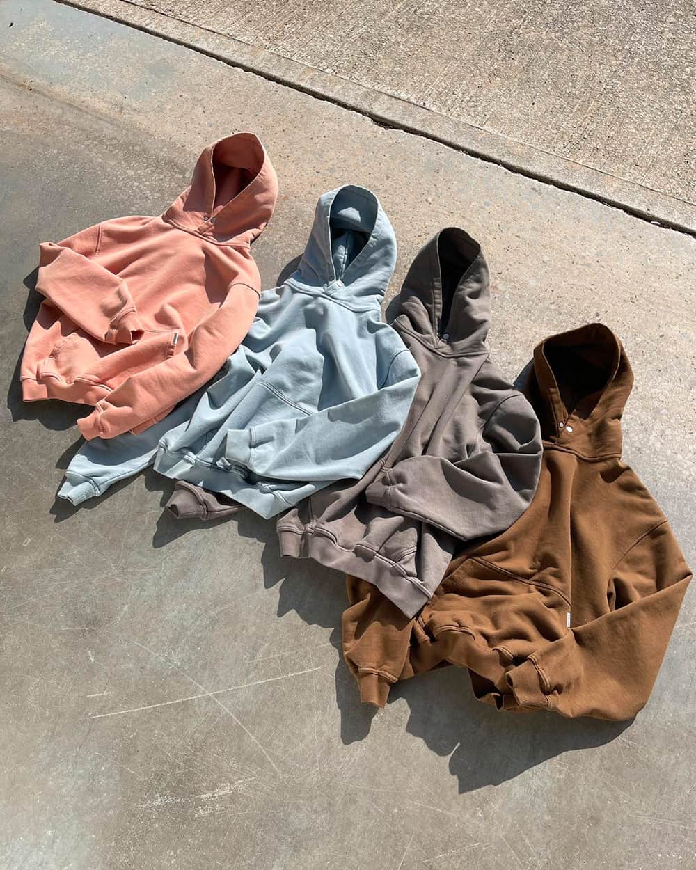A selection of oversized Represent hoodies in multiple colorways including pink, light blue, grey and brown