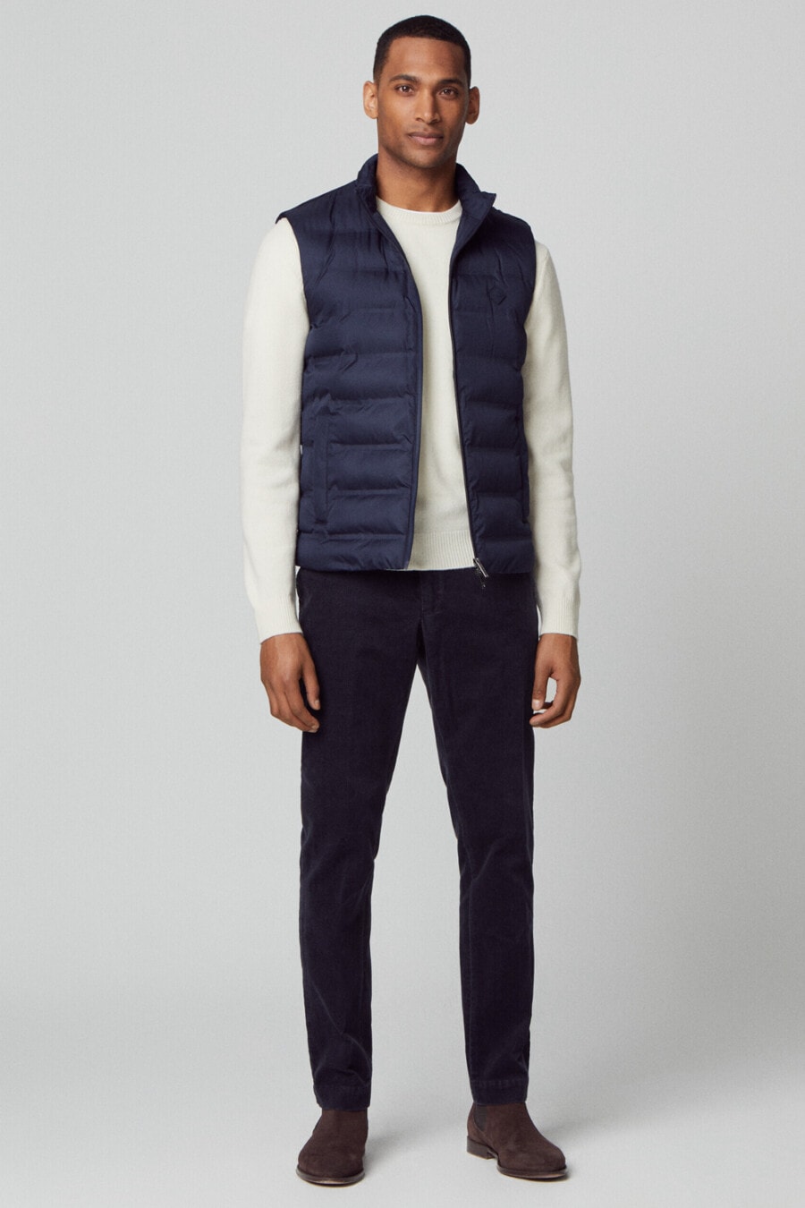 Men's navy chinos, long-sleeve white top, navy puffer jacket and brown suede Chelsea boots outfit