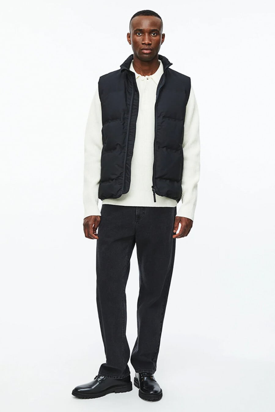 Men's black pants, white long sleeve polo shirt, black puffer jacket and black leather shoes outfit