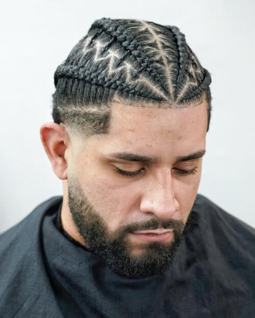 Black man with long patterned braids and a low skin fade