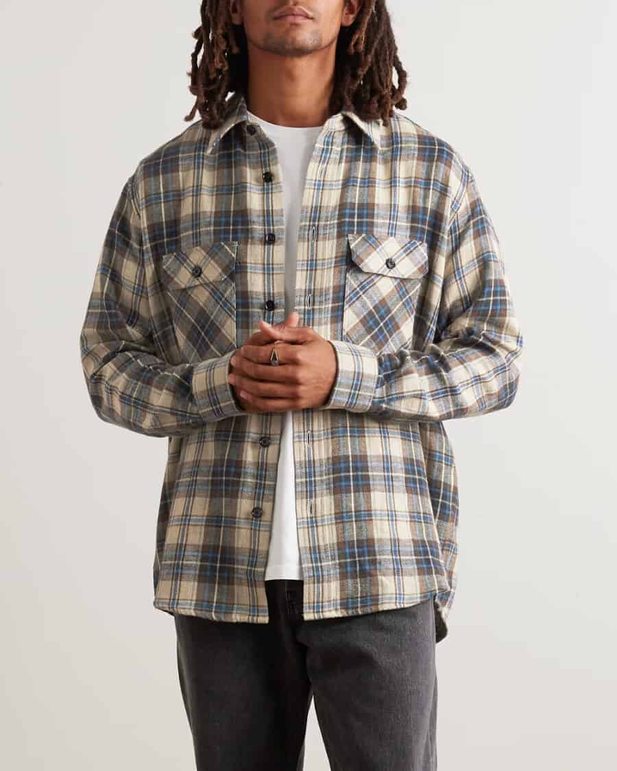 Man wearing Celine Homme cream/blue check flannel shirt over a white T-shirt with black jeans