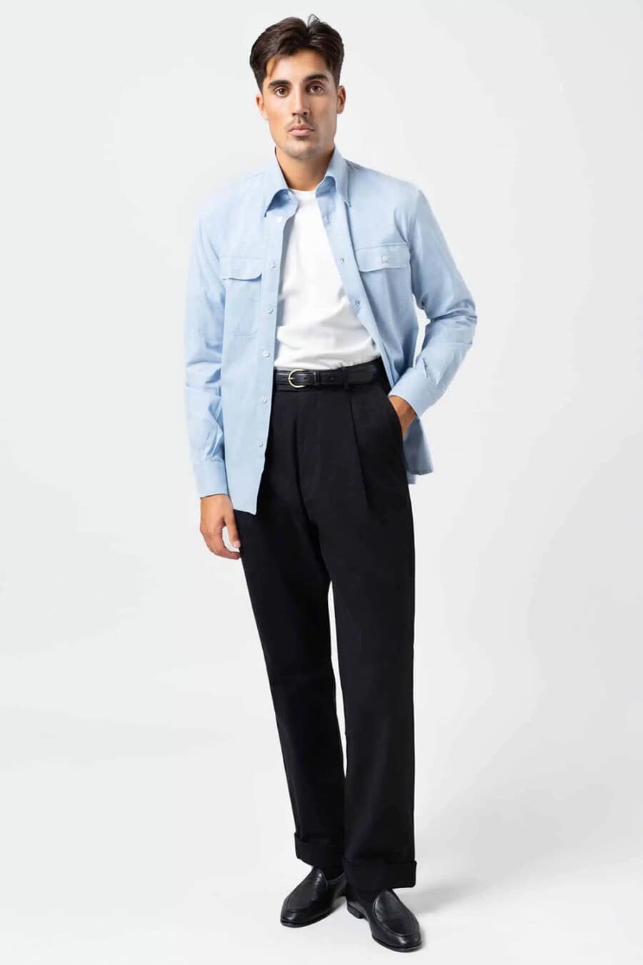 Men's pale blue overshirt, tucked in white T-shirt, navy pleated pants and black leather Belgian loafers outfit