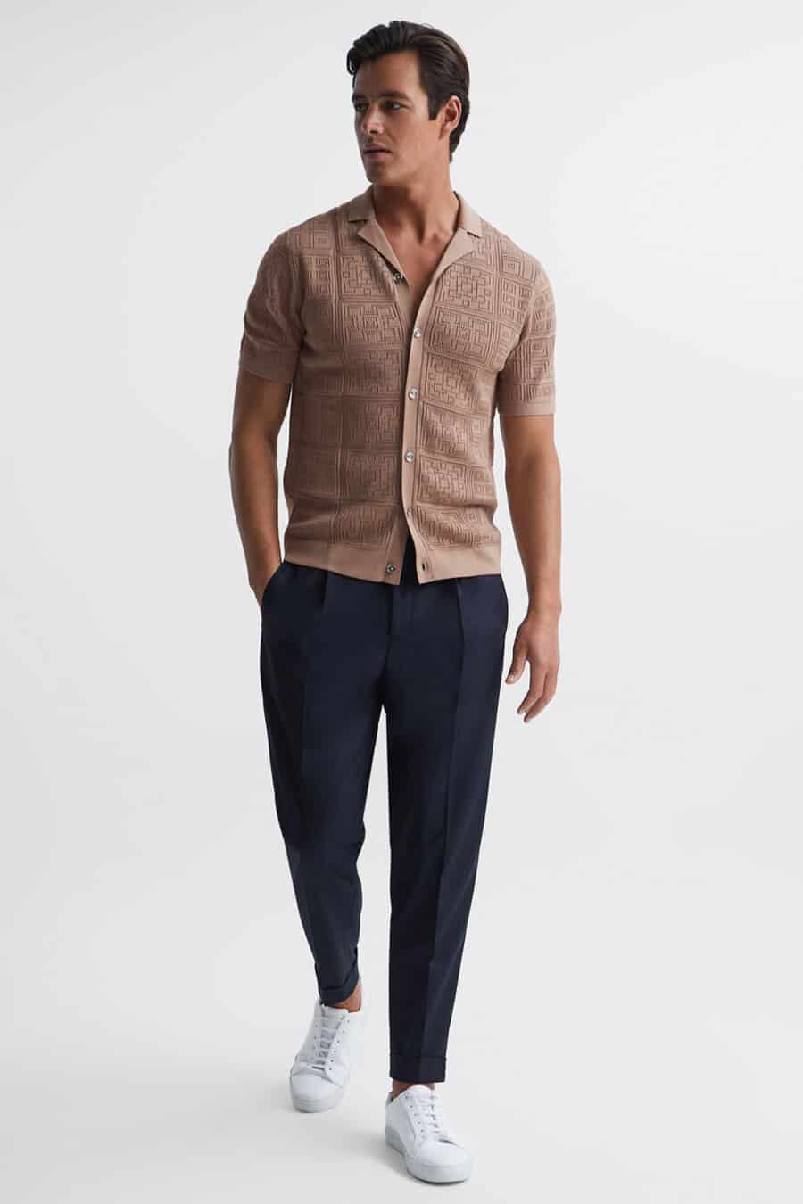 Men's navy tapered pants, brown short-sleeve knitted shirt and white sneakers worn sockless outfit