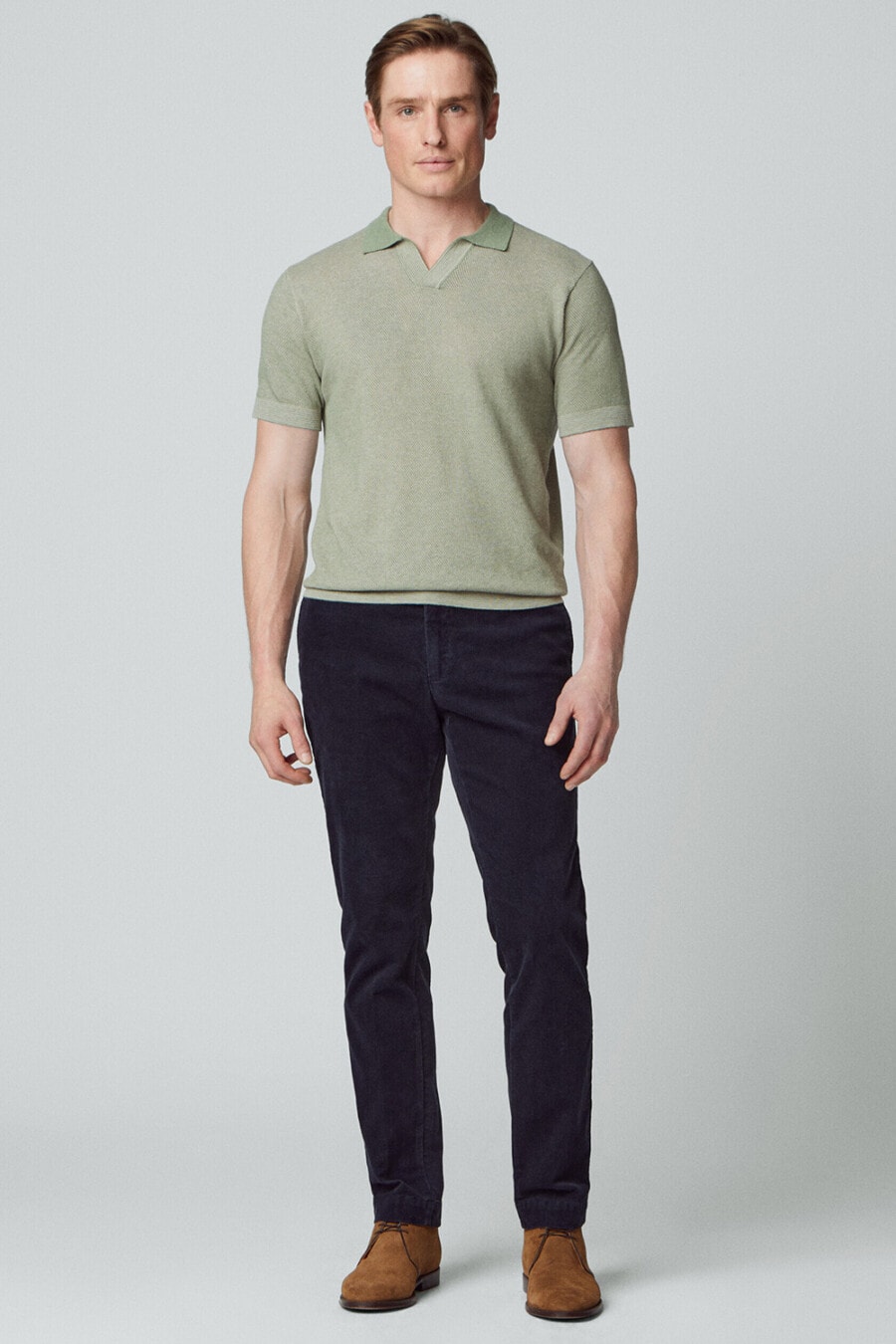 Men's navy pants, light green knitted polo shirt and tan suede chukka boots outfit