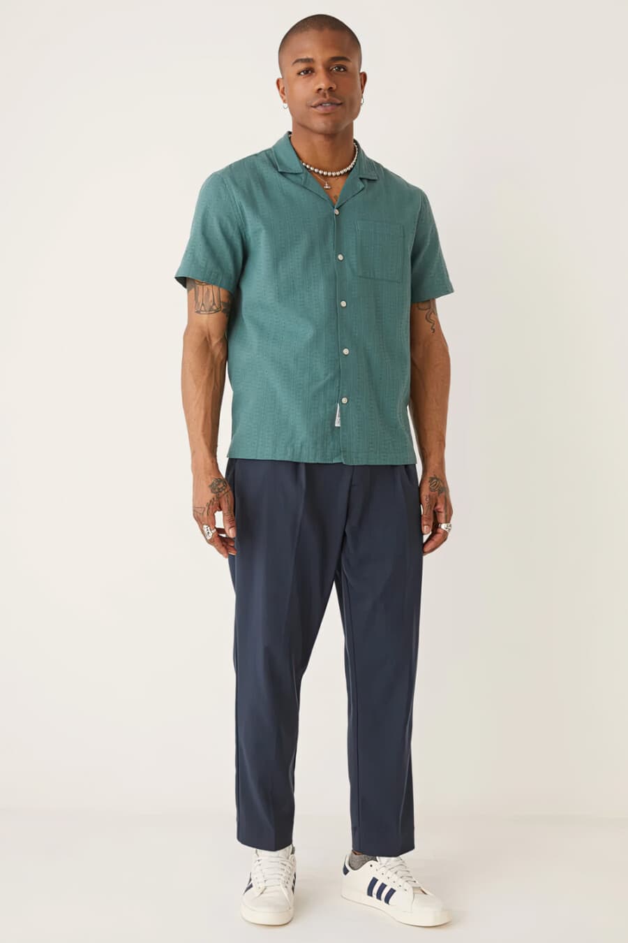 Men's aqua green short-sleeve camp collar shirt, blue loose pants, silver chunky neck chain and white adidas sneakers outfit