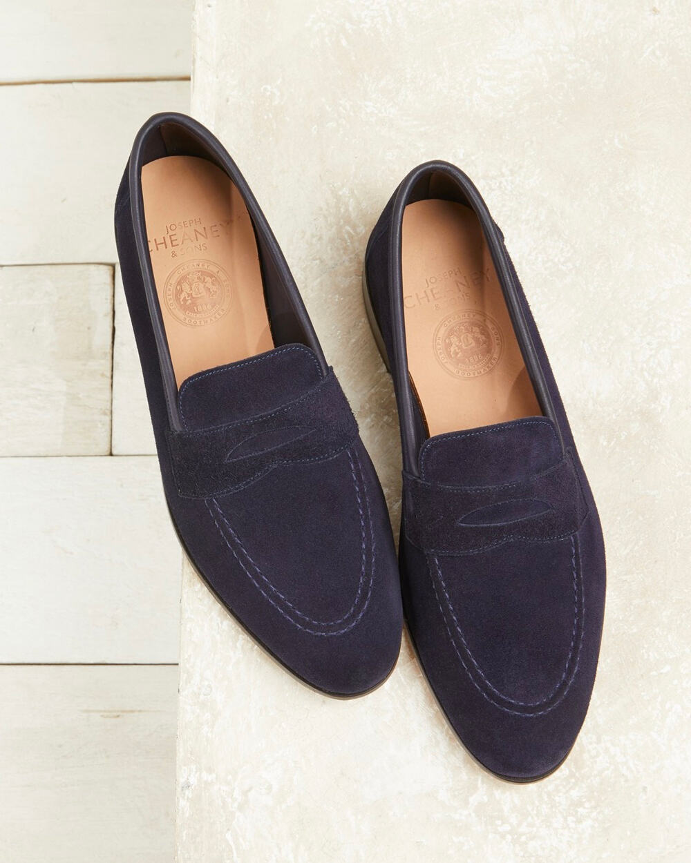 A pair of men's navy suede penny loafers by Cheaney