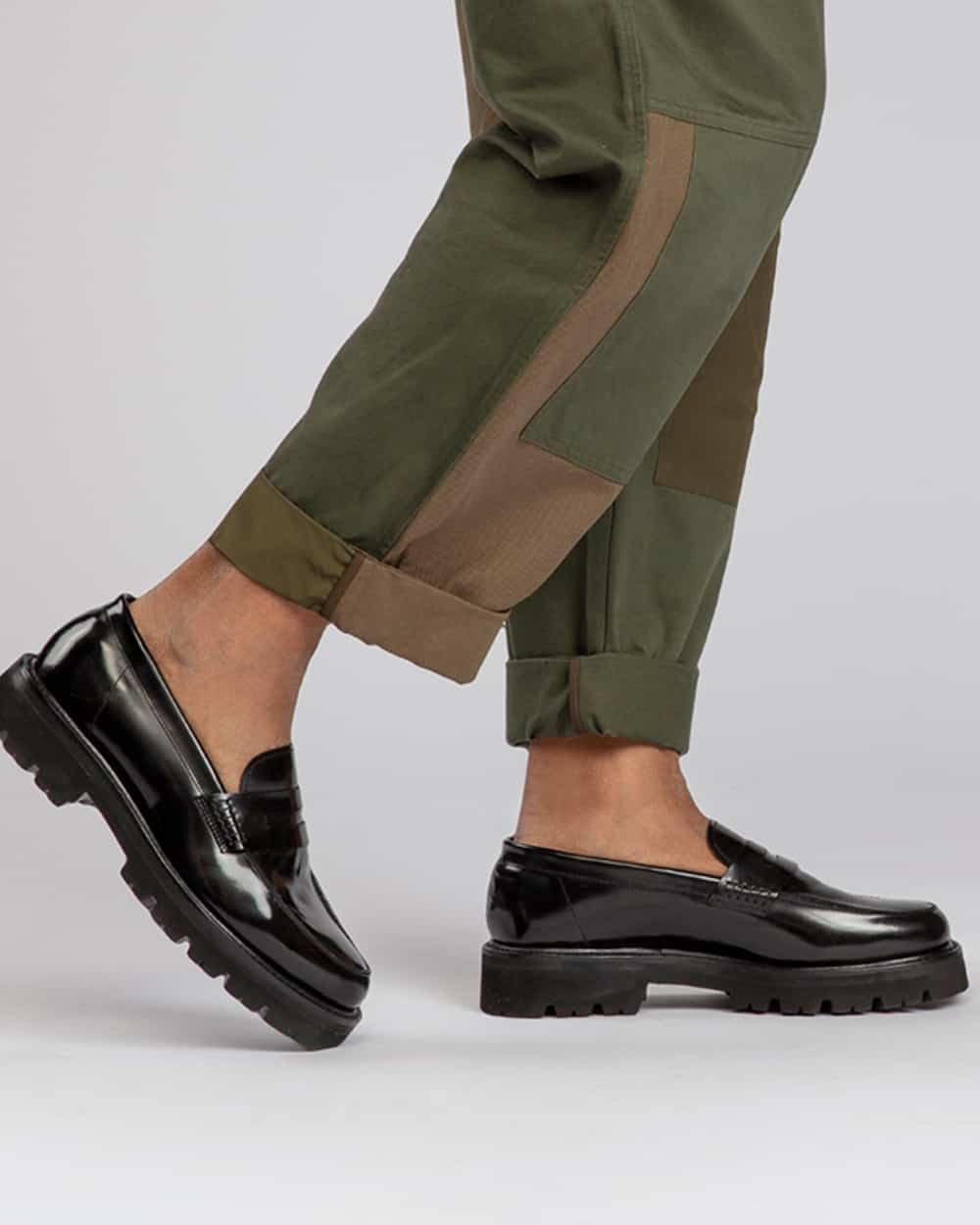 Man wearing chunky sole black leather Grenson loafers sockless with army green pants 