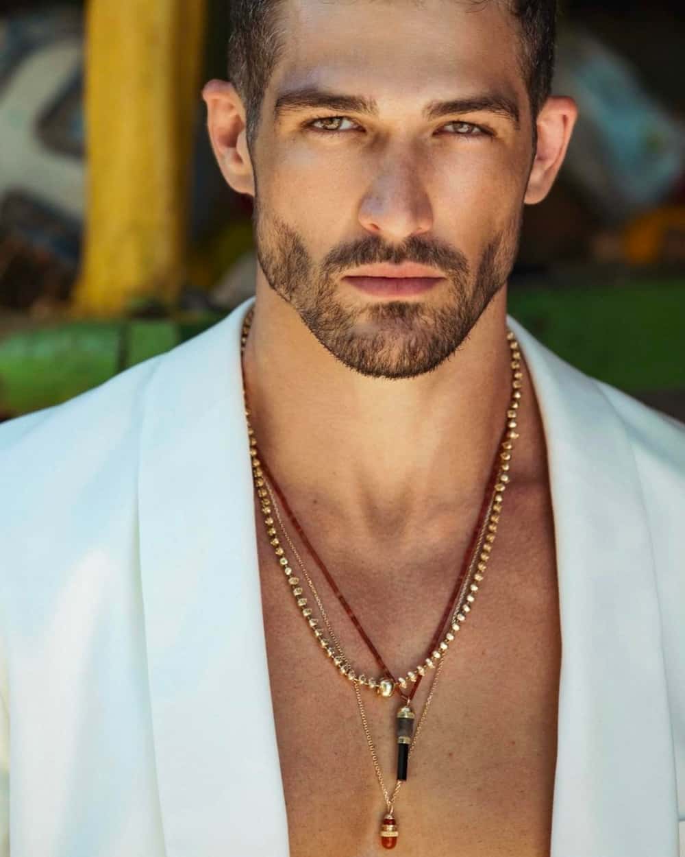 Man wearing three Luis Morais luxury pendant chain necklaces