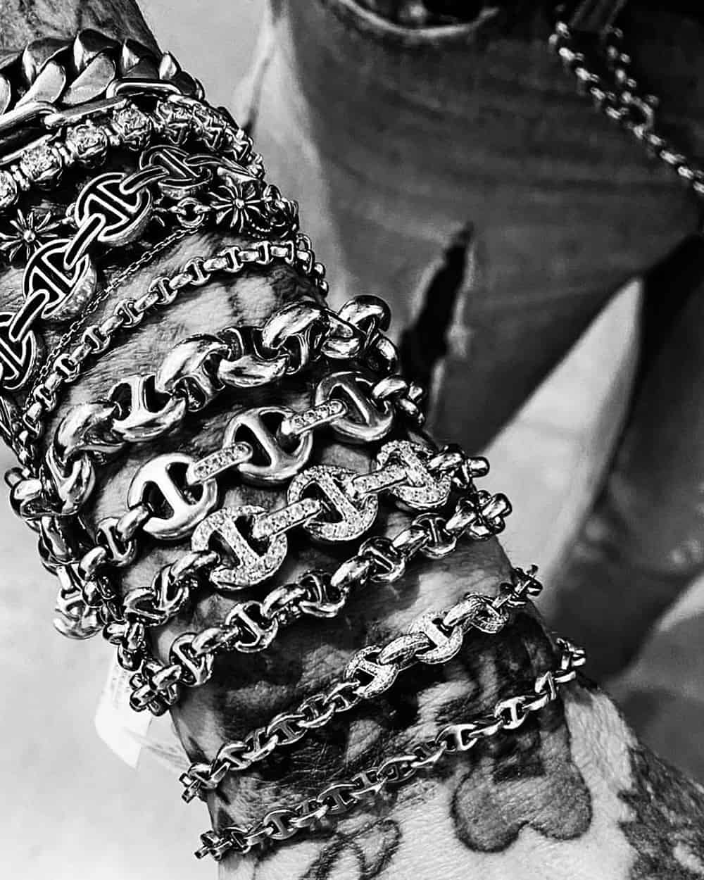 Close up of a man wearing multiple thick, chunky Hoorsenbuhs bracelets