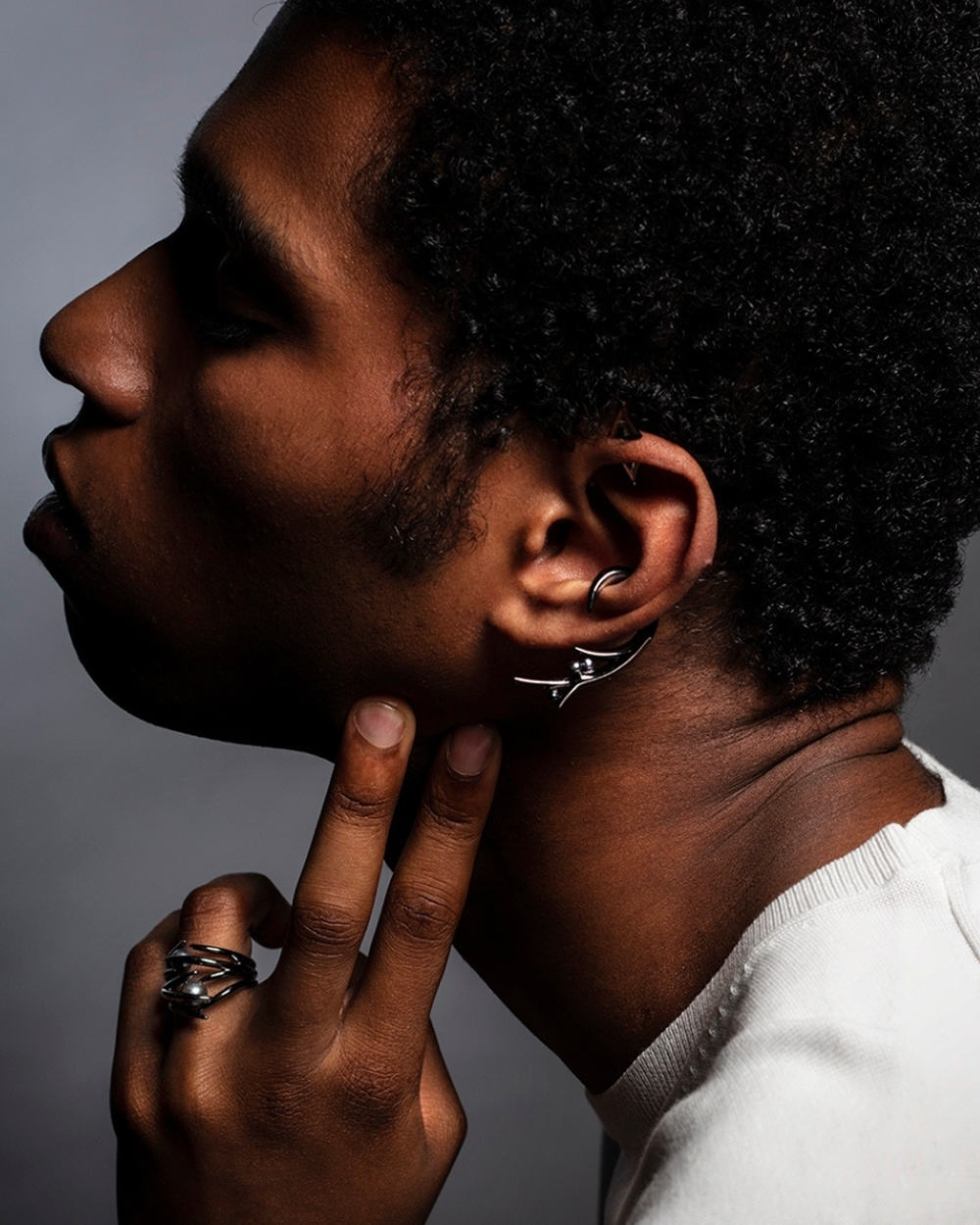 Black man wearing Shaun Leane earring and rings