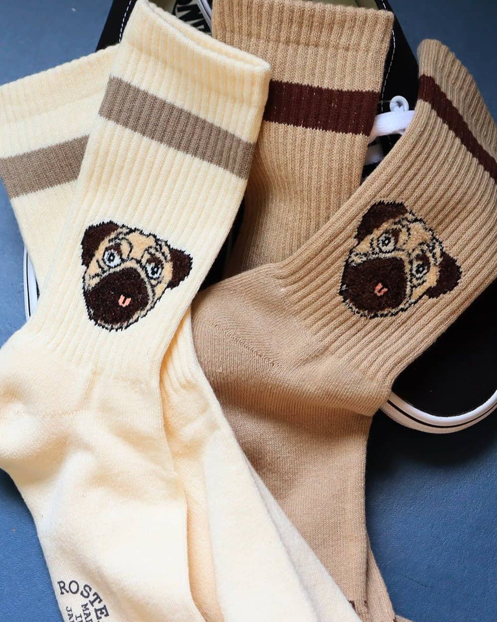 Two pairs of men's Rostersox socks with pug dog face prints in cream and brown