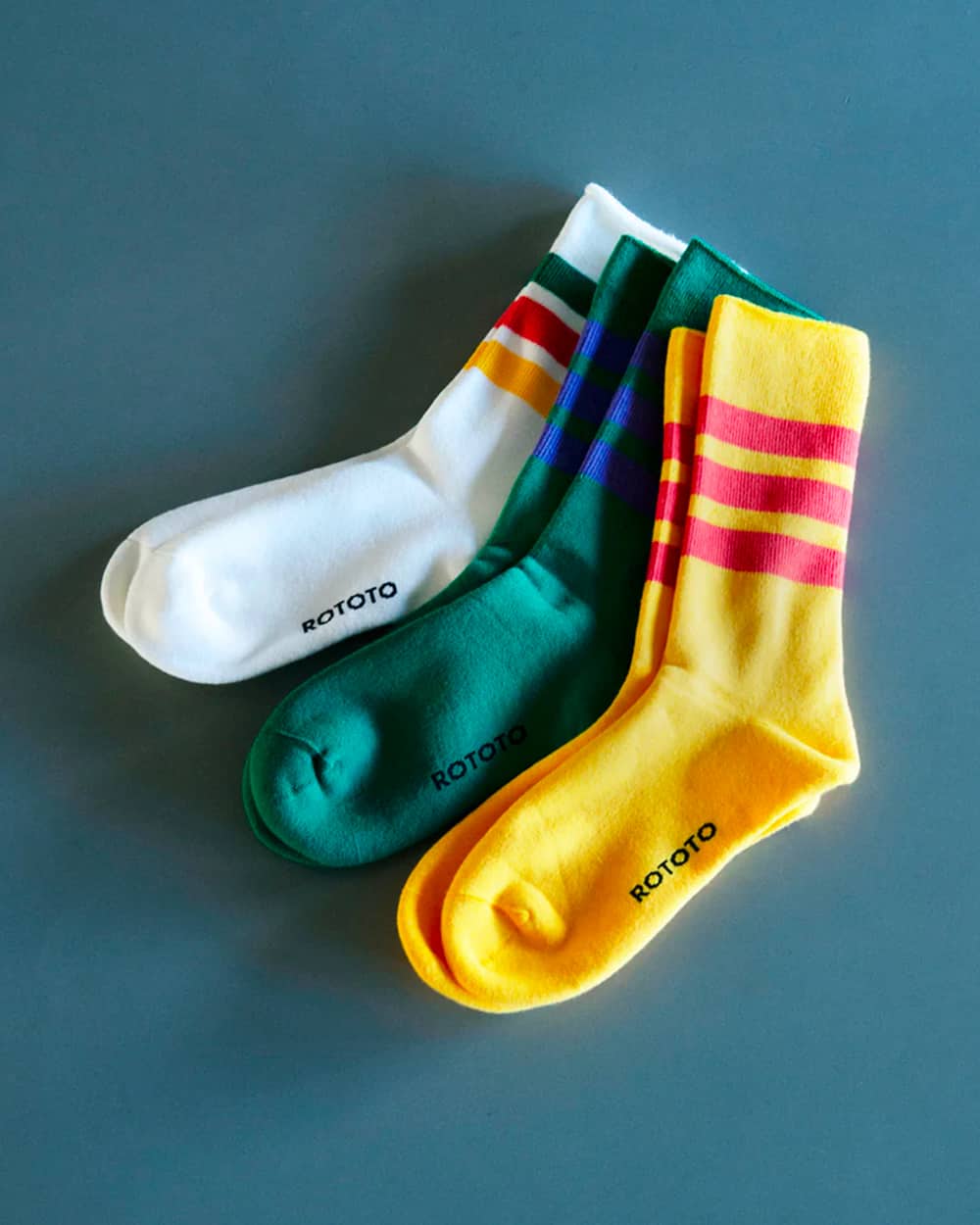 Three pairs of men's RoToTo striped socks in yellow, green and white