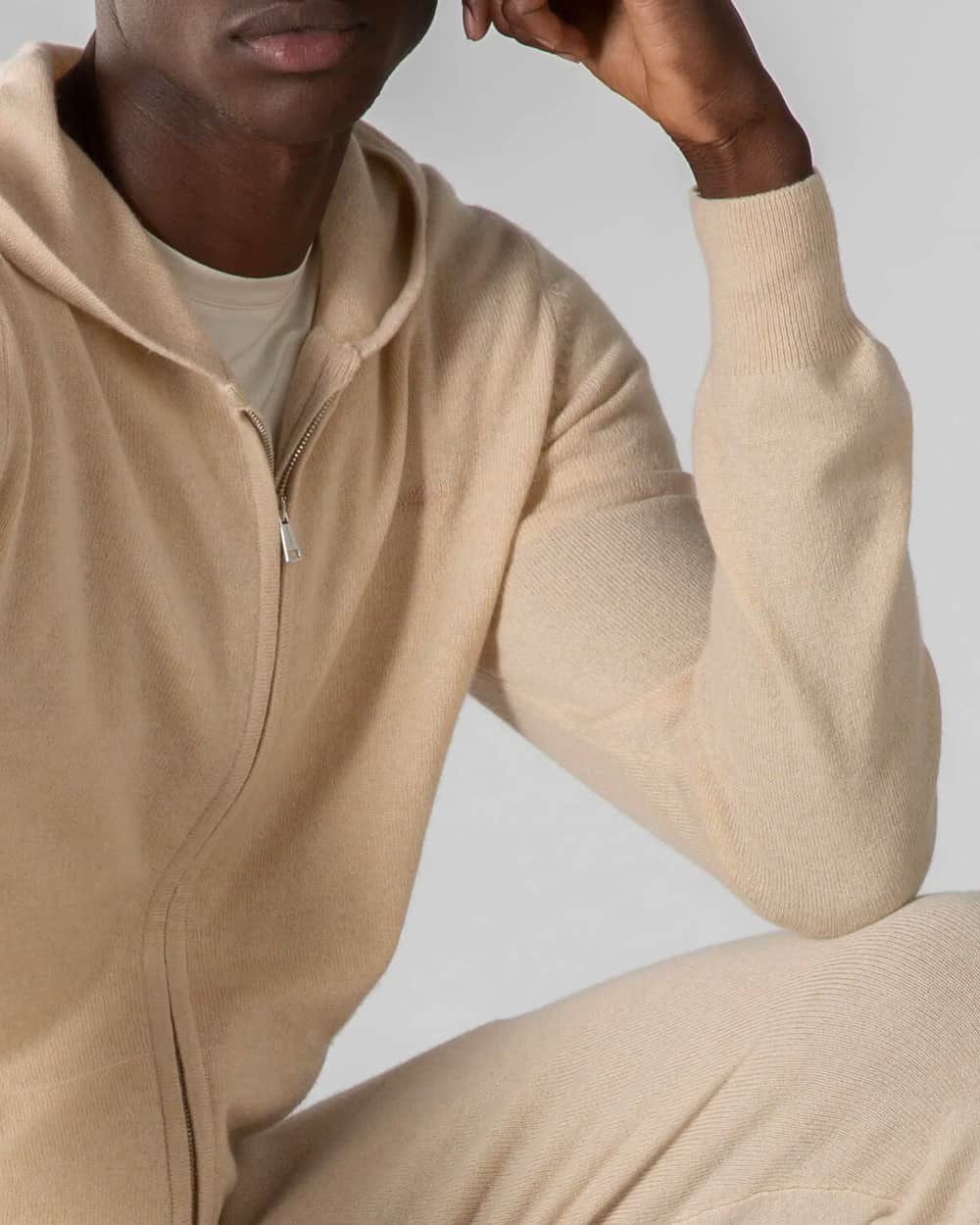 Black man wearing matching Aurelien beige cashmere hoodie and sweatpants