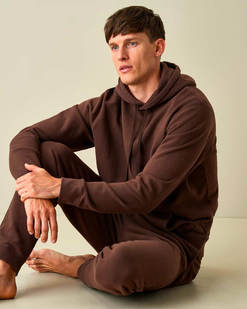 Man wearing a matching brown Sunspel hoodie and sweatpants