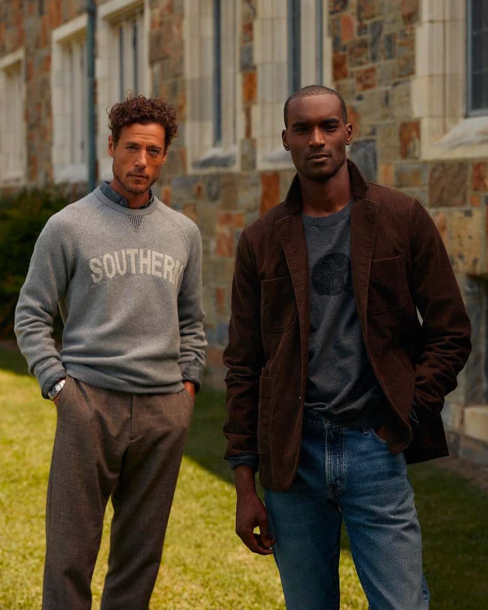 Two men wearing Billy Reid preppy clothing. One in brown pants, chambray shirt and grey printed sweatshirt and the other in mid-wash jeans, charcoal T-shirt and brown sports coat