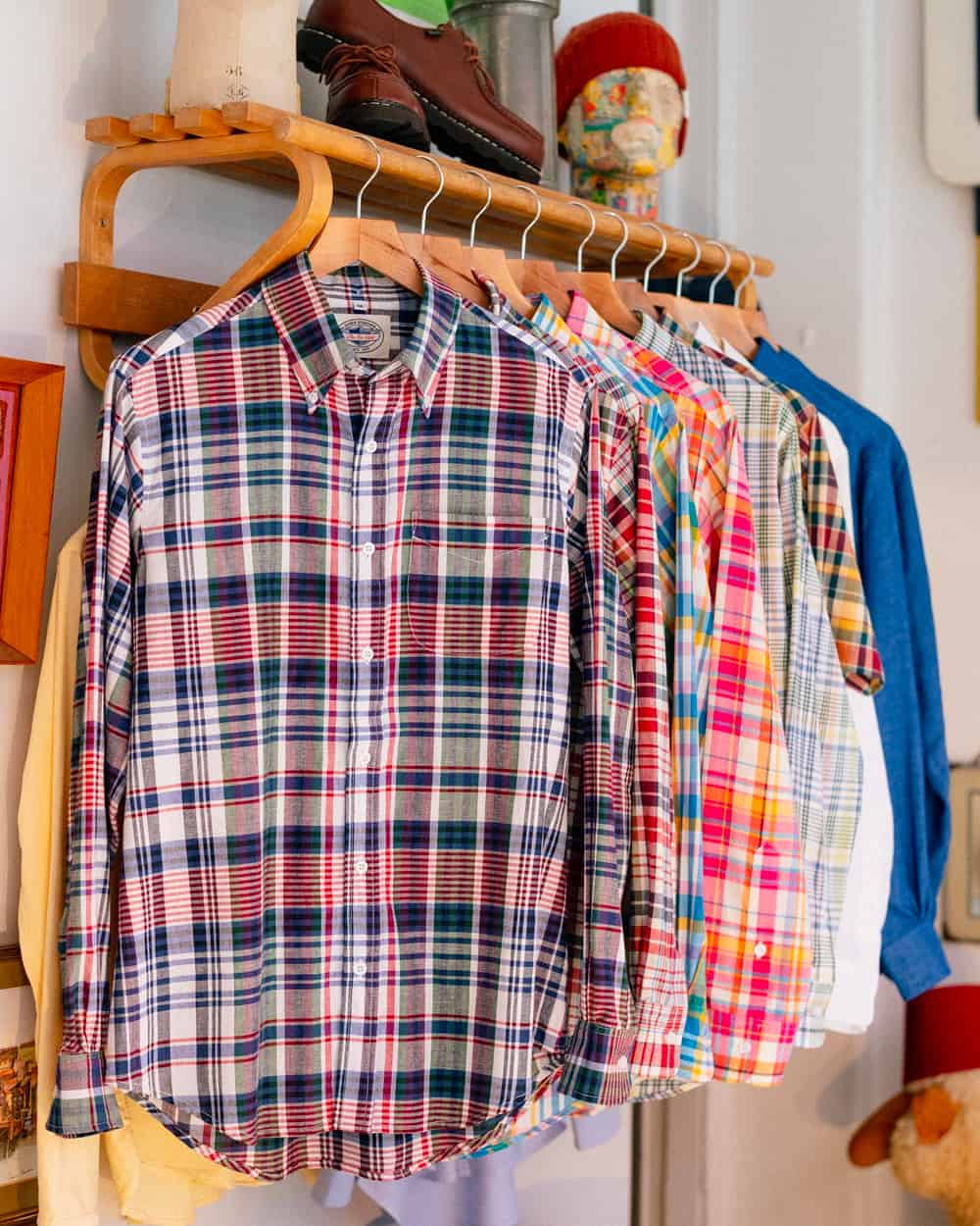 A rail of brightly colored John Simons preppy madras check shirts