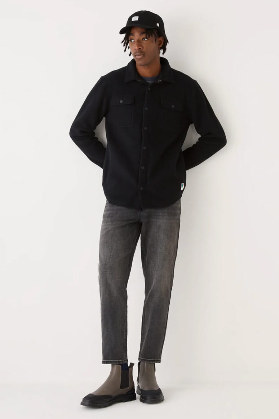 Men's dark grey jeans, black overshirt, black baseball cap and grey leather Chelsea boots outfit