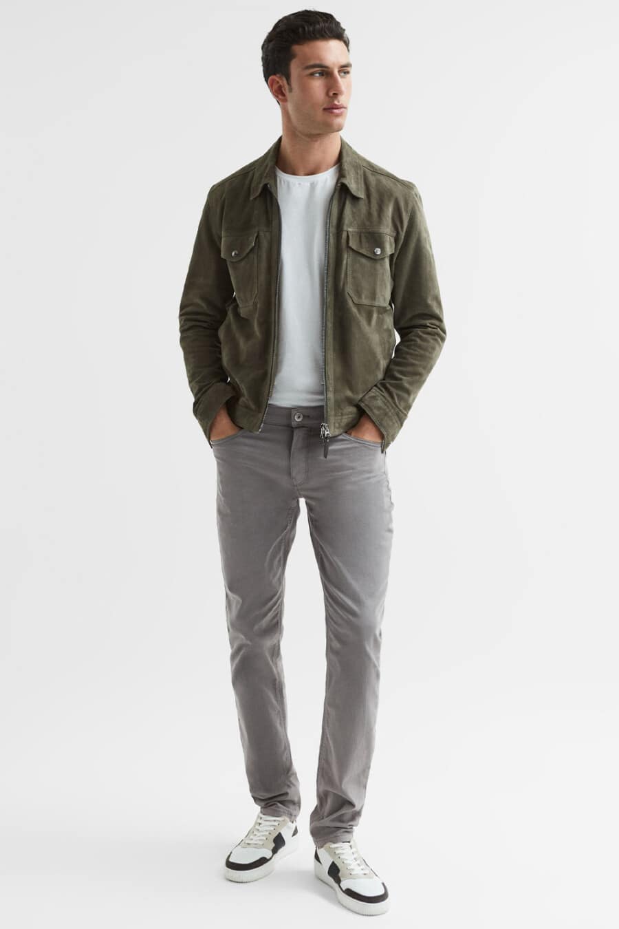 Men's grey jeans, white T-shirt, green suede jacket and white sneakers outfit