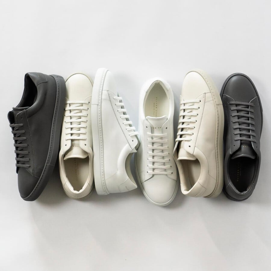 A selection of minimalist leather Oliver Cabell Low 1 sneakers in charcoal grey, off-white and white colorways