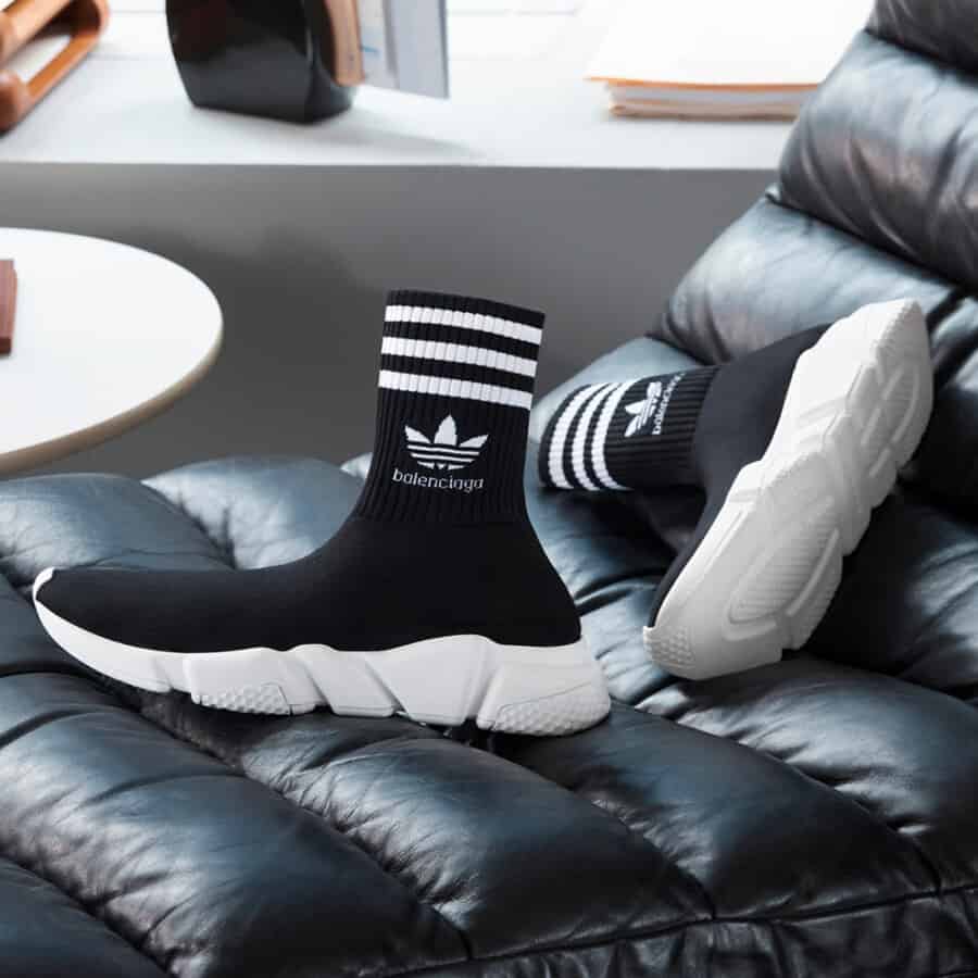 A pair of Adidas x Balenciaga black and white sock Speed sneakers on a leather chair