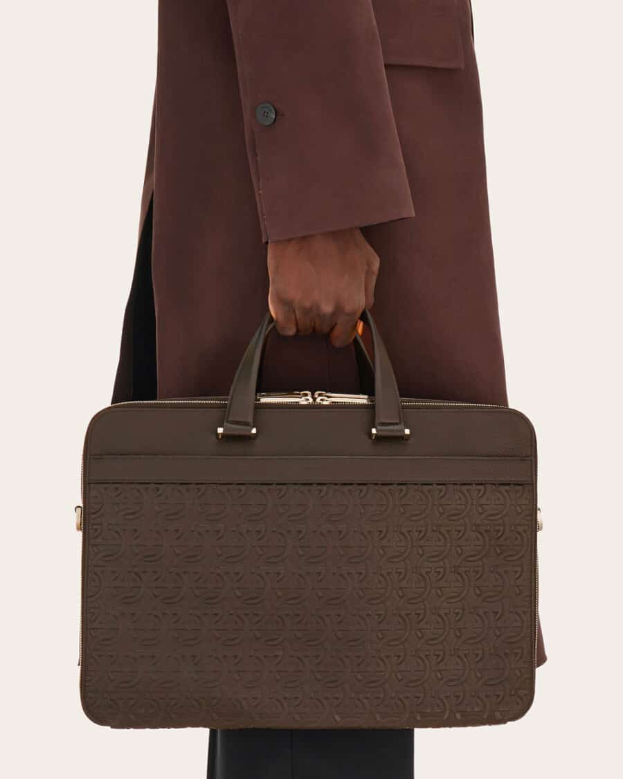 Man in a brown coat carry a brown leather luxury briefcase by Ferragamo