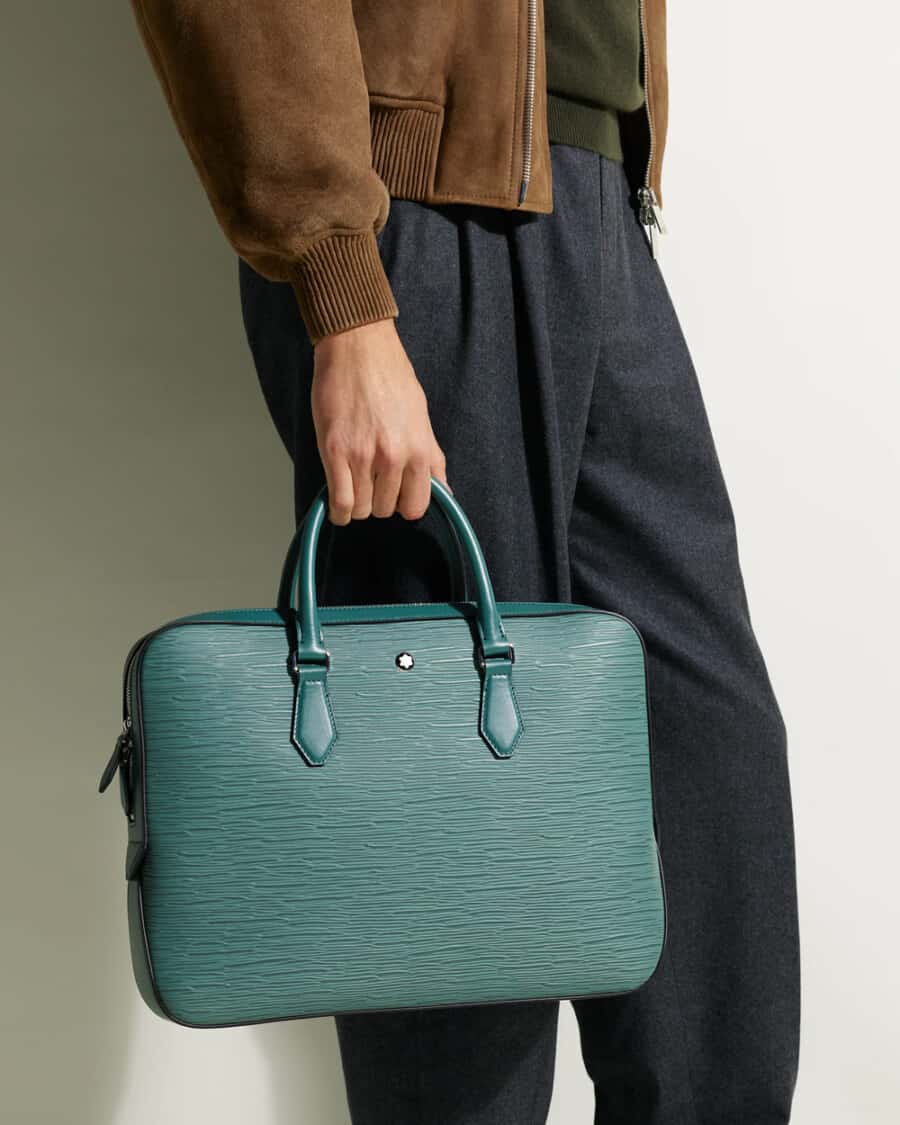 Man holding a luxury leather Montblanc briefcase in green-blue-aquamarine colorway
