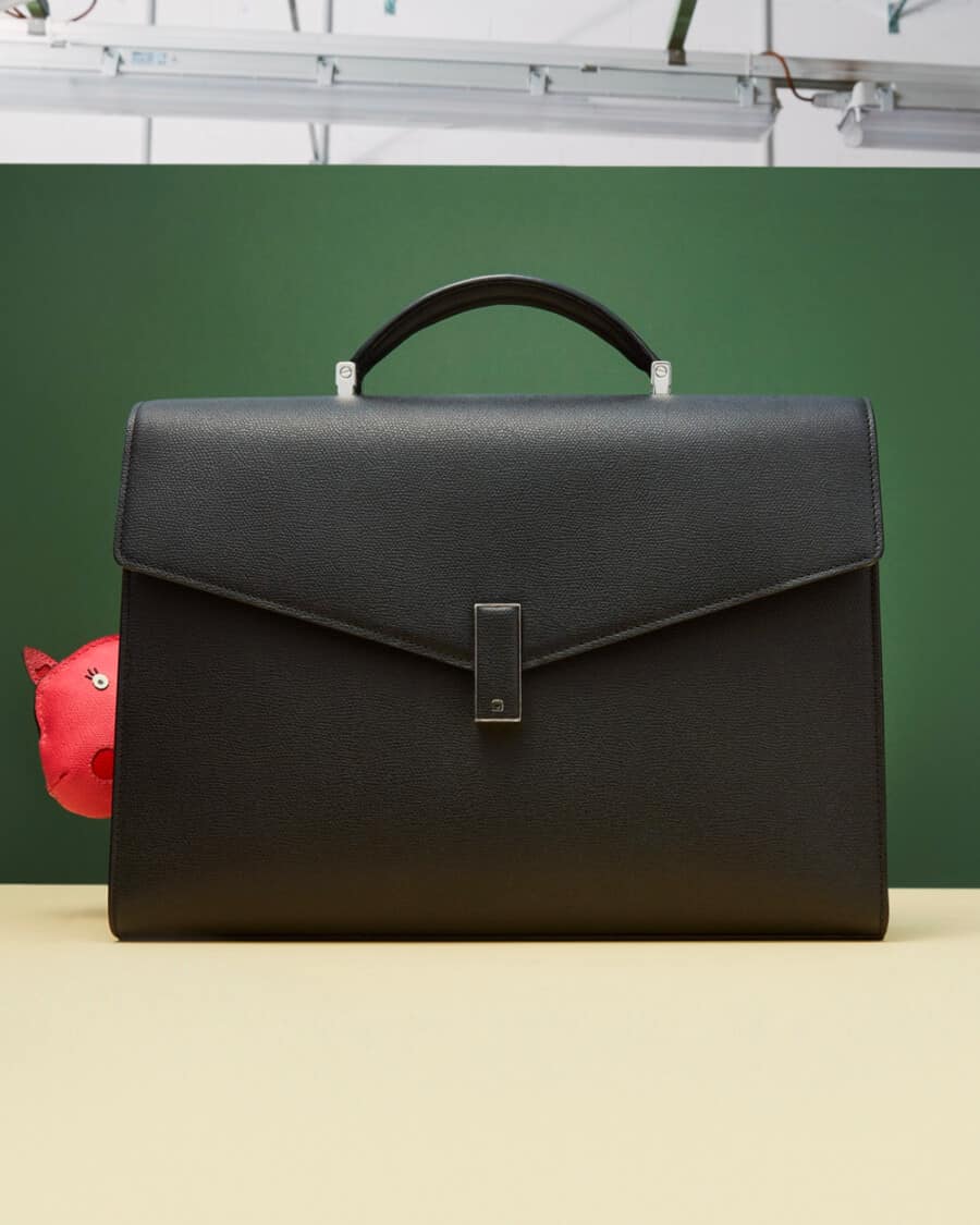 A luxury black leather Valextra briefcase with metal fastening