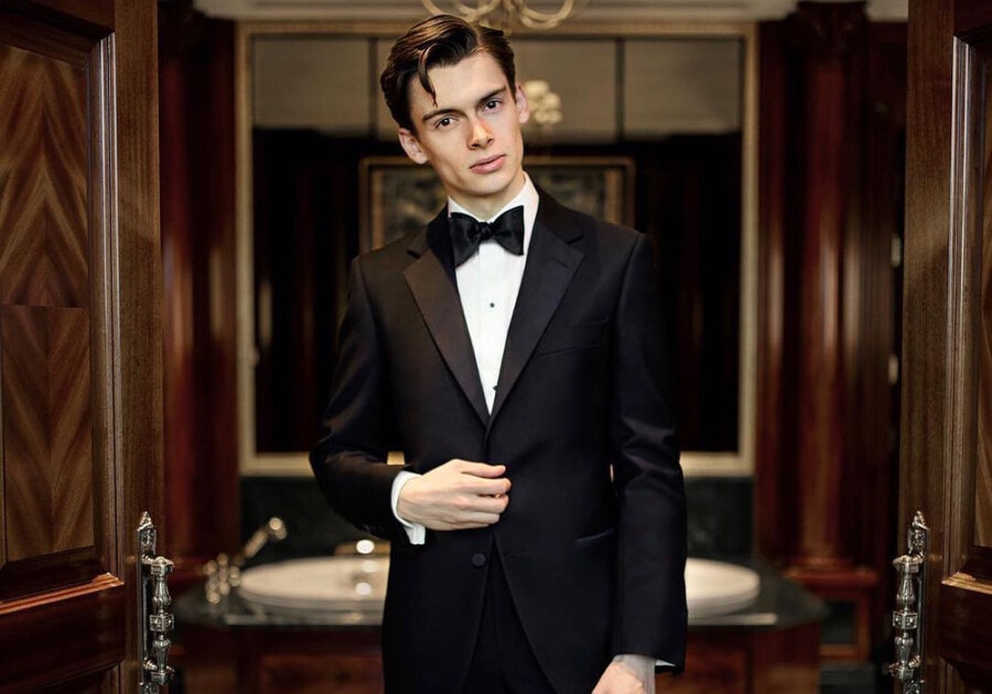 Man wearing a black tie dinner jacket tuxedo by Gieves & Hawkes with black bow tie and white marcella shirt