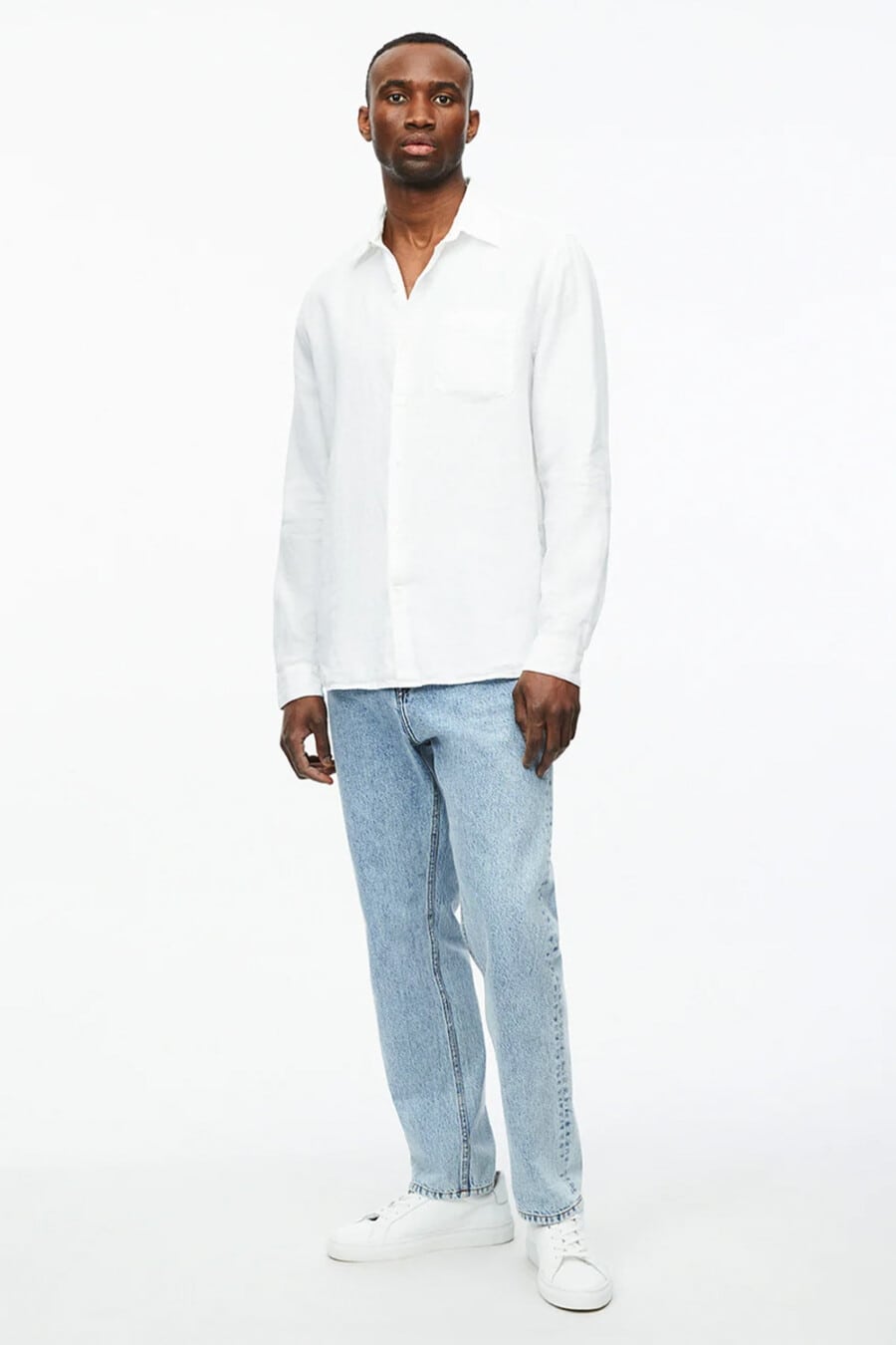 Men's light wash jeans, white shirt and white sneakers outfit