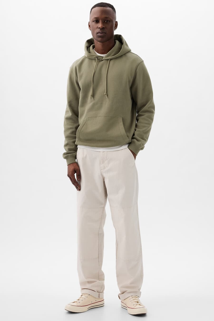 Men's loose white jeans, white T-shirt, green hoodie and off-white Converse canvas sneakers outfit