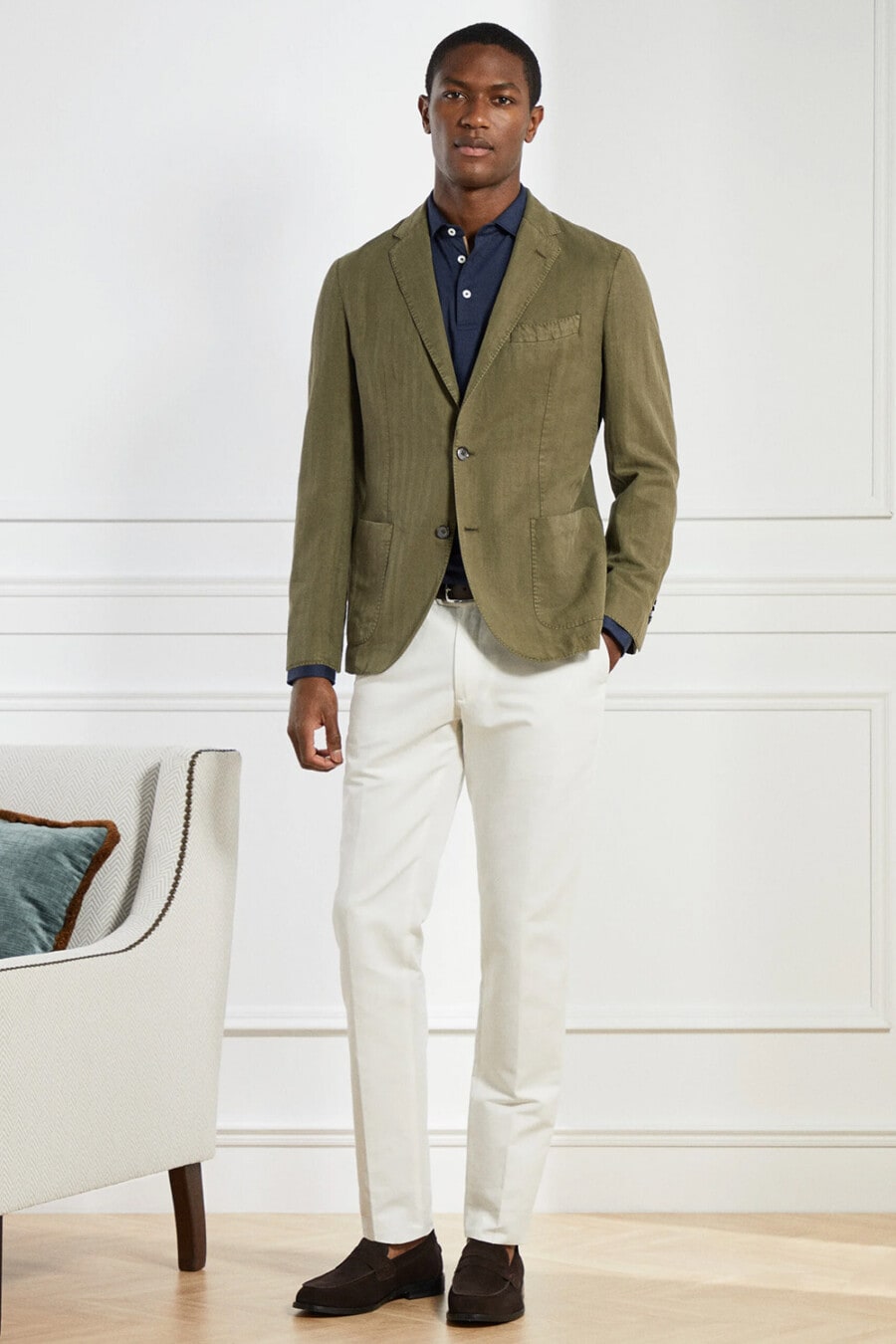Men's white chinos, navy blue shirt, green blazer and brown suede penny loafers worn sockless outfit