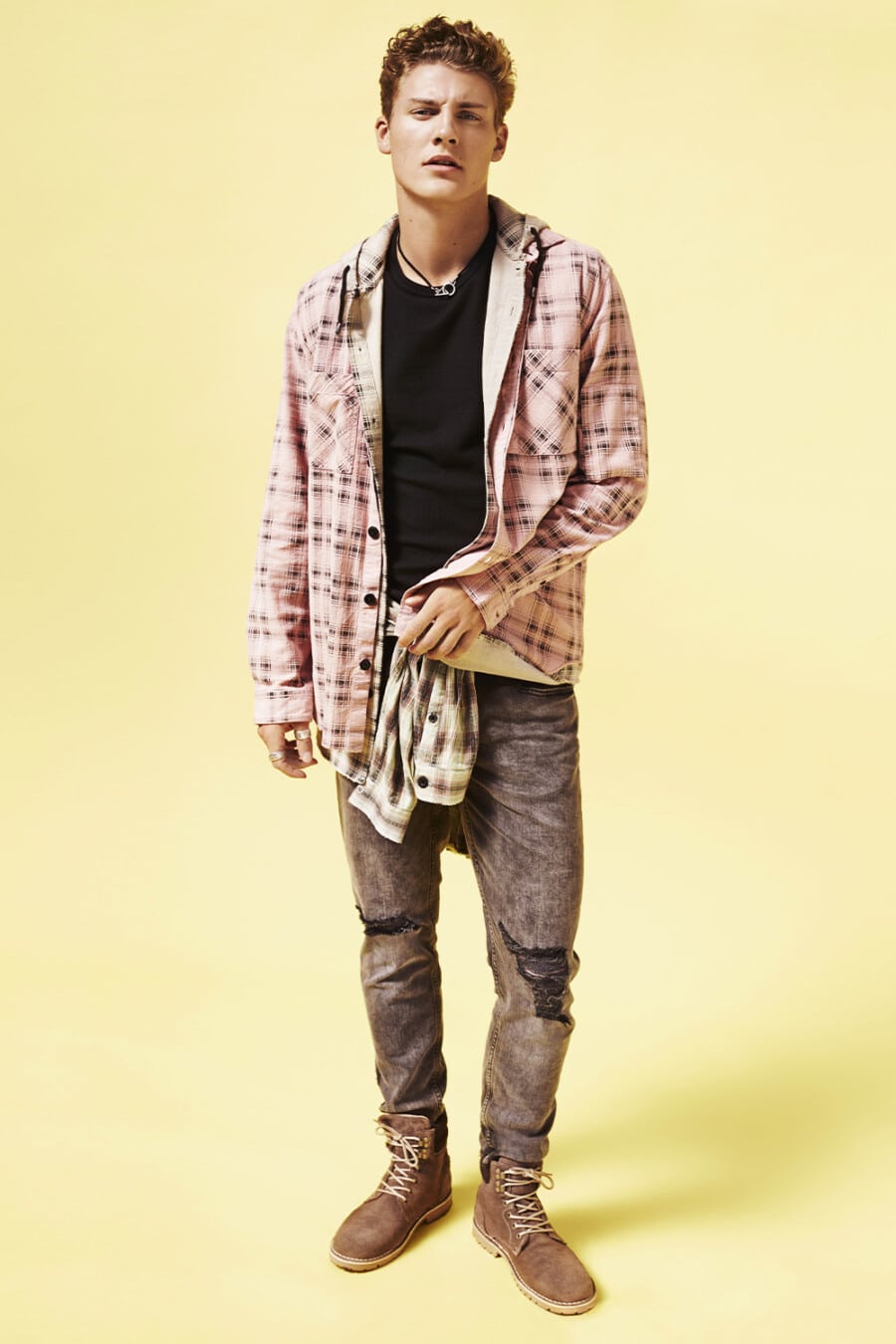 Men's ripped acid wash jeans, black T-shirt, pink check overshirt and brown suede worker boots grunge outfit