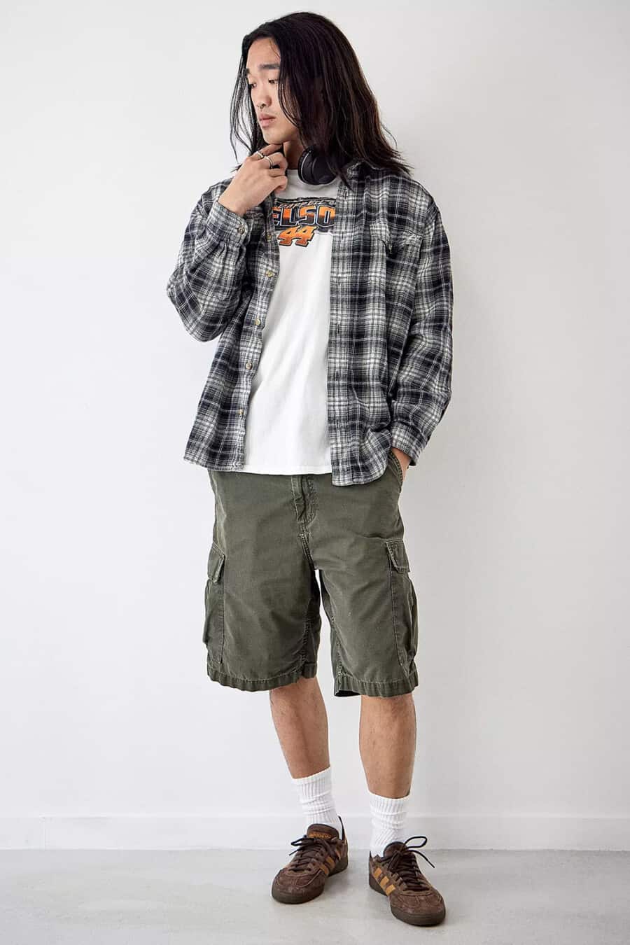 Men's baggy green cargo shorts, white print T-shirt, black/white flannel shirt, white socks and brown Adidas sneakers grunge outfit