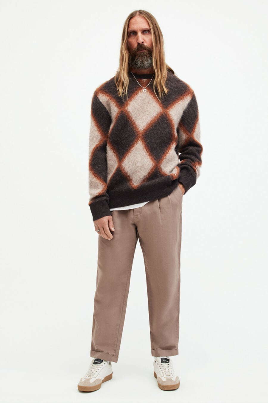 Men's wide khaki brown pants, White T-shirt, patterned brown/orange sweater and white retro sneakers grunge outfit