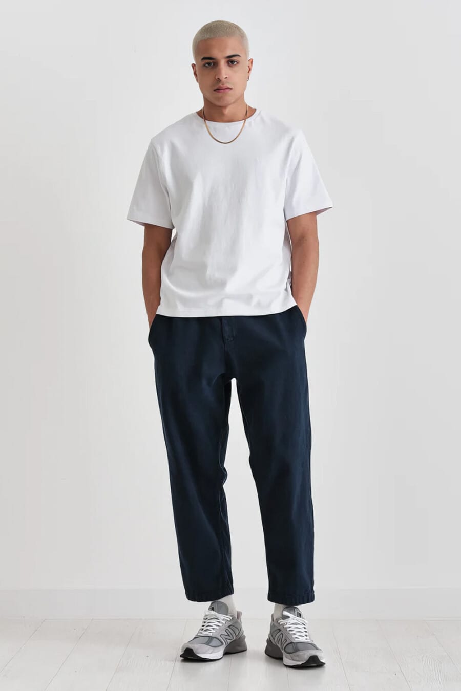 Men's wide cropped navy pants, white drop shoulder T-shirt and grey New Balance running sneakers outfit