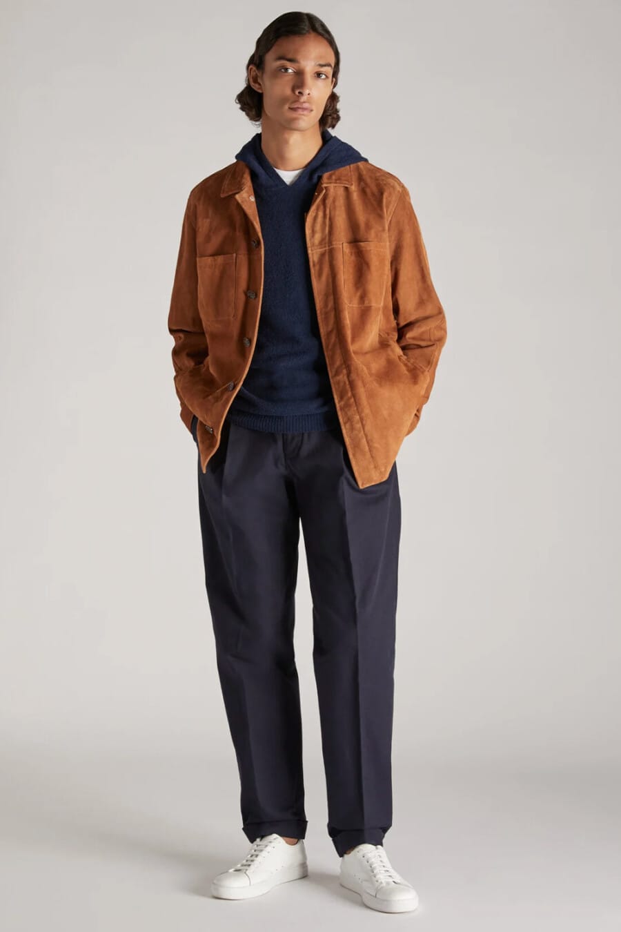 Men's wide-leg navy pants, white T-shirt, navy hoodie, tan suede overshirt and white leather sneakers worn sockless outfit