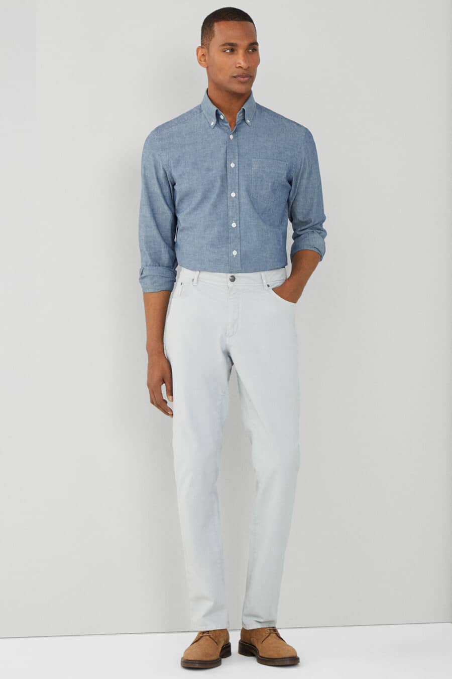 Men's white jeans, tucked in chambray dress shirt and tan suede Derby shoes outfit